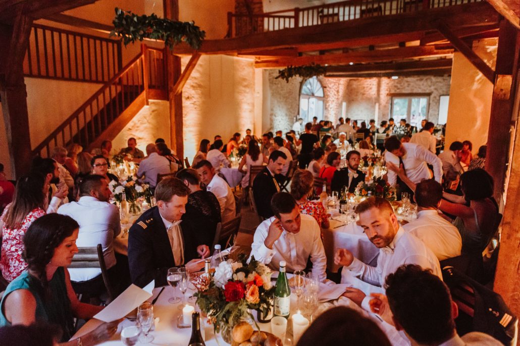 Dîner de mariage dans la grange sous mise en lumière chaleureuse — Domaine de Tilh à Loubieng, Sud Évènements Sonorisation